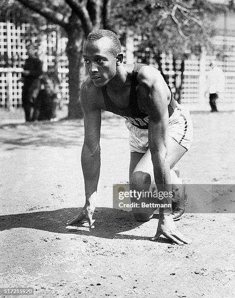 Berlin, Germany- Jesse Owens, triple winner in the Olympics, is shown above, crouched for a start in a workout several days before he captured firsts...