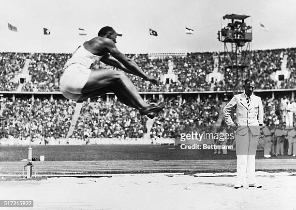 Berlin, Germany- Jesse Owens soars through the air with the greatest of ease for a distance of 26 feet 5-221/64 inches, bettering the Olympic mark,...