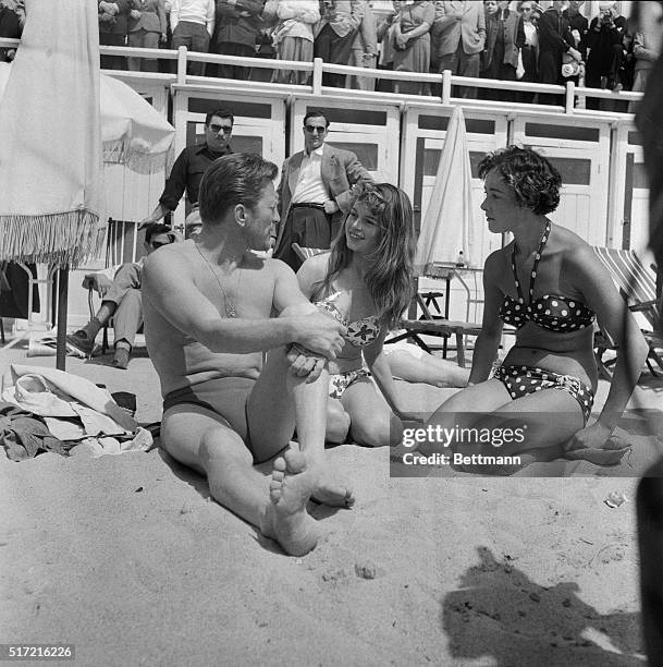 American actor Kirk Douglas seems engrossed in conversation with pretty French starlet Brigitte Bardot, as they sun themselves on the Cote D' Azur...