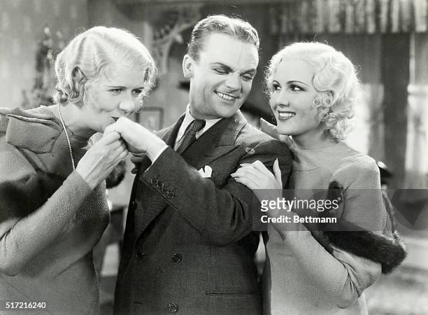 Picture shows a scene from the movie, "Hard to Handle". James Cagney is shown between Ruth Donnelly and Mary Brian. He is winking at Brian while...