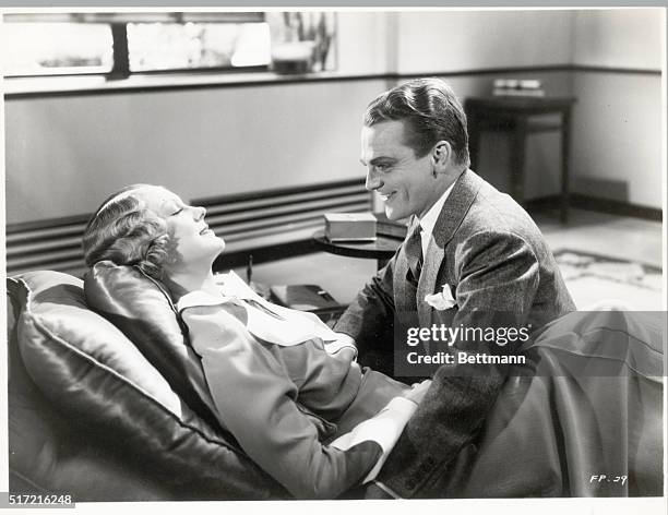 Picture shows actors James Cagney and Claire Dodd in a scene from the movie, "Footlight Parade". Dodd is shown lying on a lounge with Cagney seated...