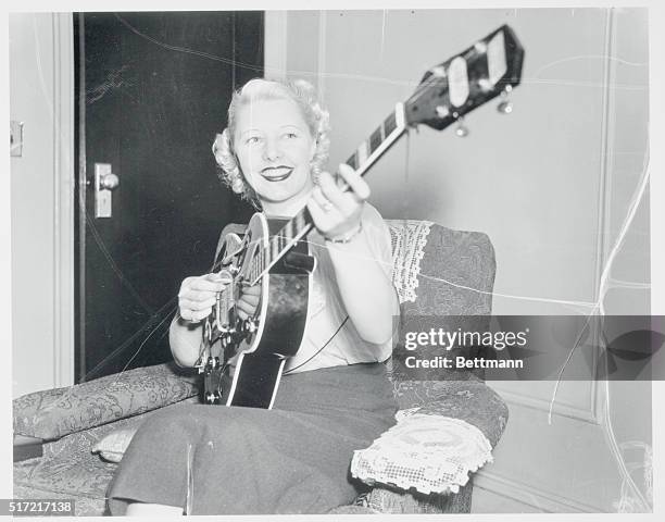 Mrs. Ken Harvey playing the newly invented electric guitar.