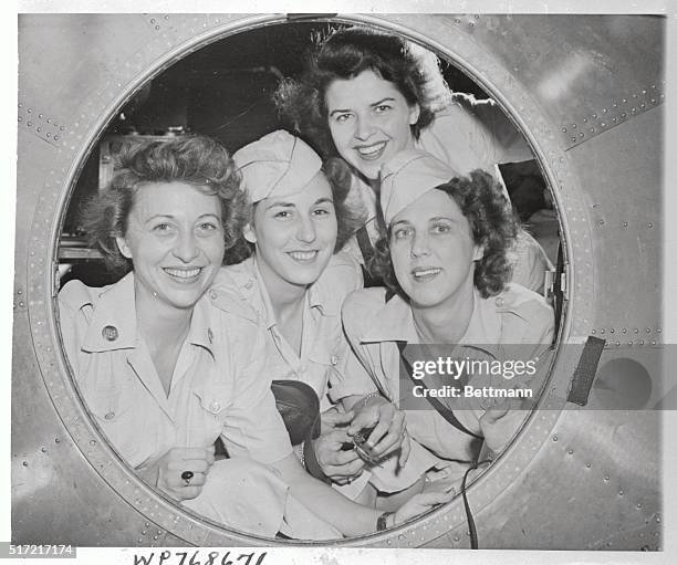 Smiling through porthole in a B-29 superfortress based at Harmon Field, Guam, are four of the first WACs assigned to the island. Left to right:...