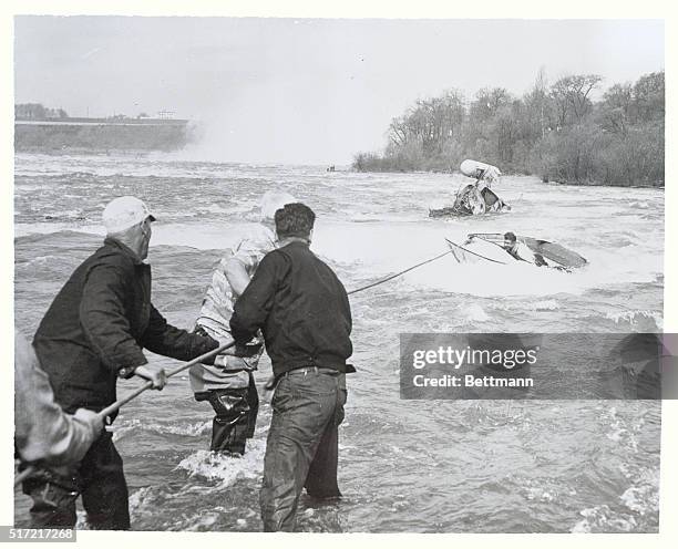 Crew of firemen haul ashore a small boat containing Joe Cannon, copilot of the helicopter that crashed in an attempt to rescue Mrs. Jean Bugay from...