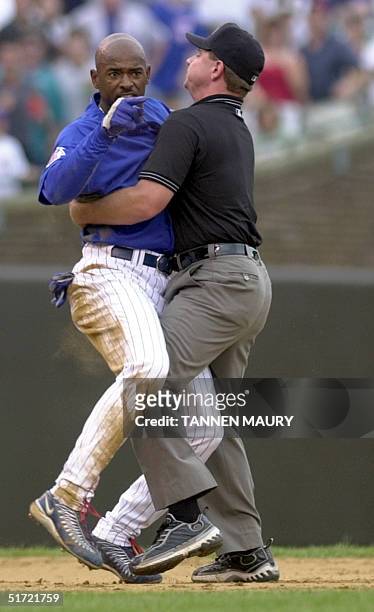 Chicago Cubs outfielder Michael Tucker is restrained by Umpire Greg Gibson as Tucker has words with St. Louis Cardinals infielder Fernando Vina in...