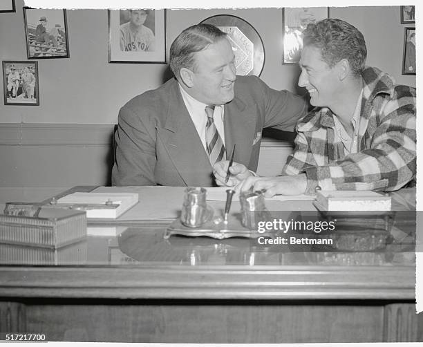 Ted Williams, , voted most valuable player in the American League, signs his 1960 contract, February 7th, for an estimated $100,000. The fellow at...