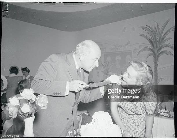 Cecil B. Demille is shown offering a piece of his birthday cake to star Madeleine Carroll during the luncheon in honor of the Pioneer producer at the...