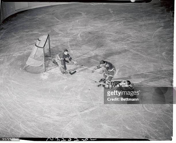 Woodrow "Porky" Dumart, No. 14, of the Boston Bruins, is foiled in his attempt at a score in the first period of the game between the Bruins and the...