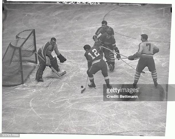 Sid Abel, of the Detroit Red Wings lines the puck up here for a shot at the Brooklyn Americans net in the first period at Madison Square Garden, but...