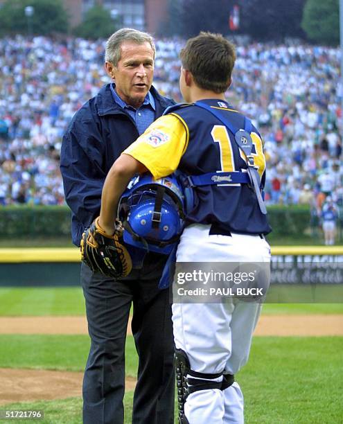 President George W. Bush receives the baseball from Apopka, Florida catcher Will Blankenship after throwing the first pitch to open the championship...