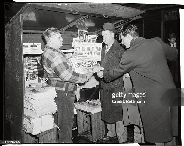 Interested passersby stop at Sol Meyerson's newsstand at Broadway and 42nd Street, March 4, to look at the afternoon papers headlining the "serious...