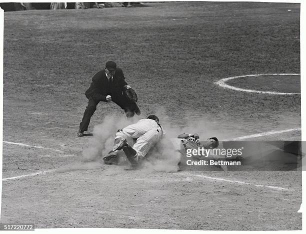 Shortstop Willie Miranda of the Chicago White Sox is out at home as New York Yankee catcher Yogi Berra throws himself into putting on the tag. Umpire...