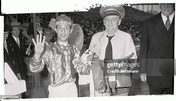 Star jockey Eddie Arcaro signifies his fourth "hundred grand" victory of the Santa Anita Race Track season, on March 7th. He took top honors for the...