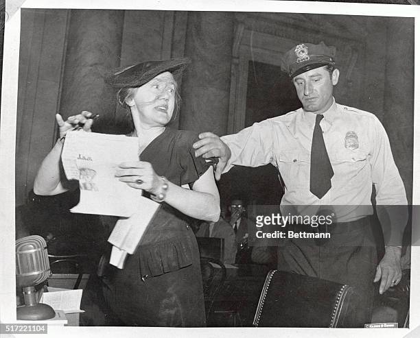Photo shows Mrs. Agnes Waters, who said she represented the National Blue Star Mothers of America, being escorted from the hearing for exceeding the...