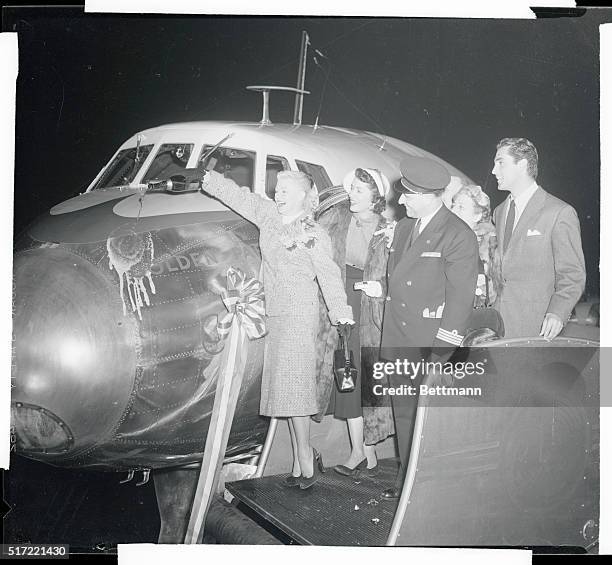 Film star Ginger Rogers pours champagne on the nose of the Golden Parisian to christen the new Air France overnight airliner before its inaugural...