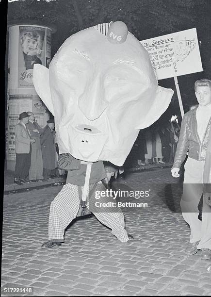 Social Democrats Mock Adenauer. Bremen, Germany: A huge head, caricaturing Chancellor Konrad Adenauer, is carried during a mass anti-Adenauer...