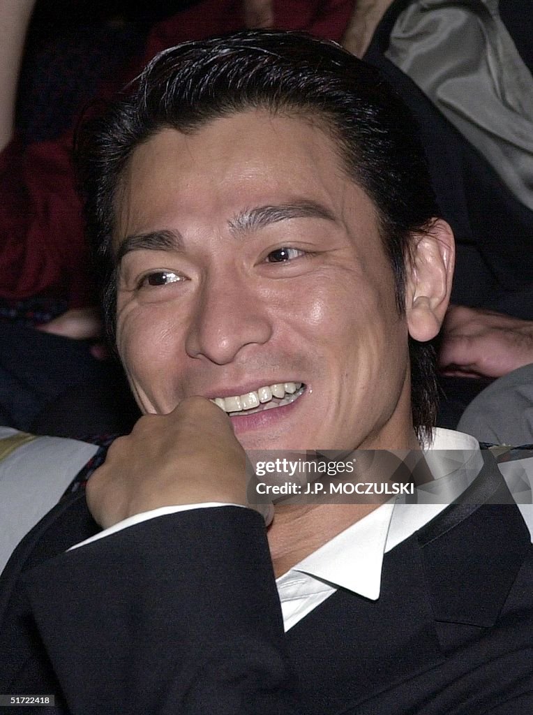 Asian film star Andy Lau smiles at boisterous fans