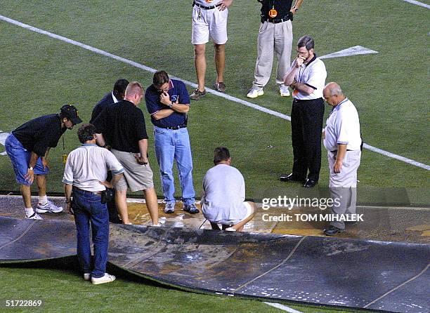 Officials from the National Football League and stadium personnel from Veterans Stadium in Philadelphia, inspect the subsurface of the artificial...