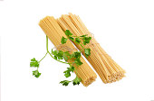 Two different uncooked long pasta and sprigs of parsley