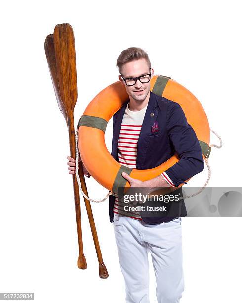 biondo fiducioso giovane uomo che tiene delle boe e paddle - sailor foto e immagini stock