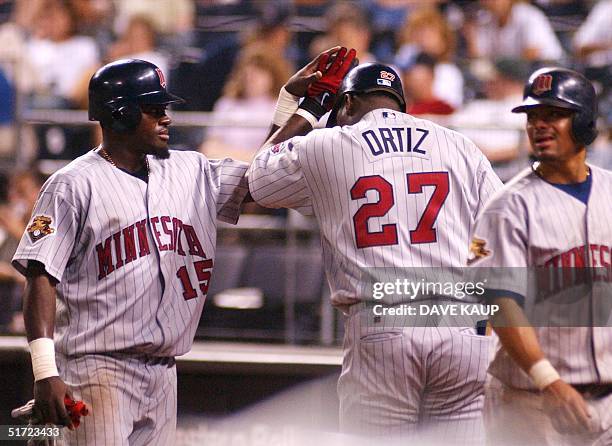 Minnesota Twins Cristian Guzman is congratulated by teammate David Ortiz after he and Luis Rivas scored on a single by Corey Koskie in the ninth...