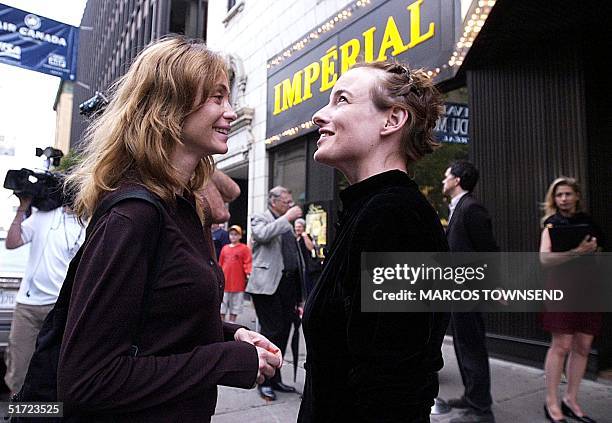 French actress Emmanuelle Beart talks to Canadian actress Pascale Bussieres outside the Imperial Theater 28 August in Montreal. Beart is a jurist at...