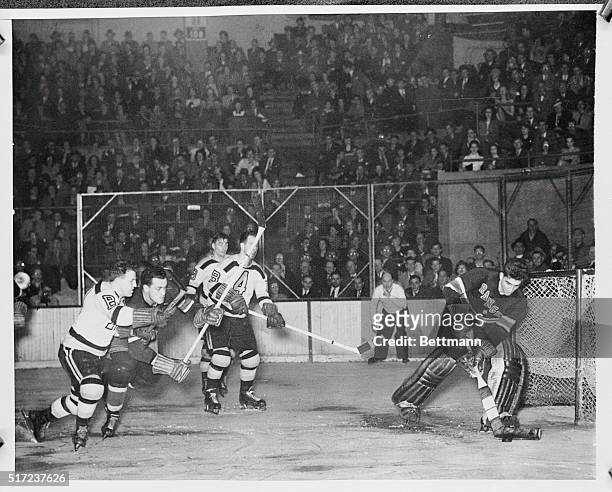 Goalie Chuck Rayner of Rangers makes a save in front of the net, halting the puck driven at him by Boston Bruins Bobby Bauer . Action was seen on...