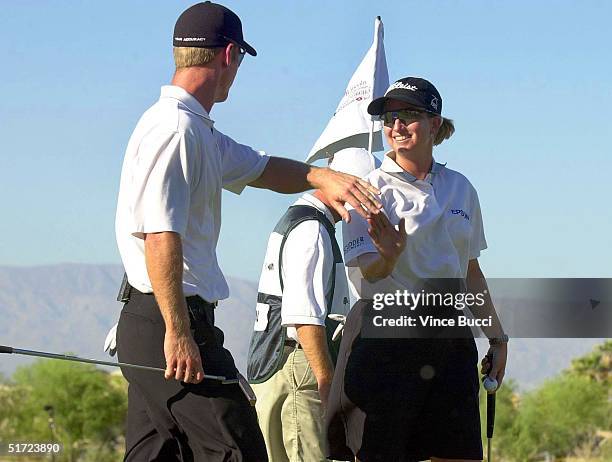 Teammates David Duval and Karrie Webb exchange a high five after Webb made a birdie on the third hole at the Bighorn Golf Club during the Lincoln...