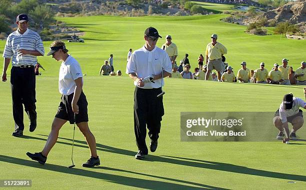 Karrie Webb prepares to putt on the third hole as teammate David Duval and opponents Annika Sorenstam and Tiger Woods approach at the Bighorn Golf...