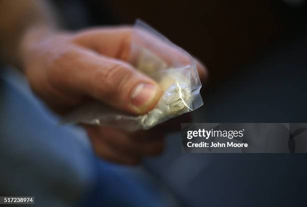 Police officer holds a bag of heroin confiscated as evidence on March 22, 2016 in Gloucester, MA. Last June Gloucester created the Angel Program,...