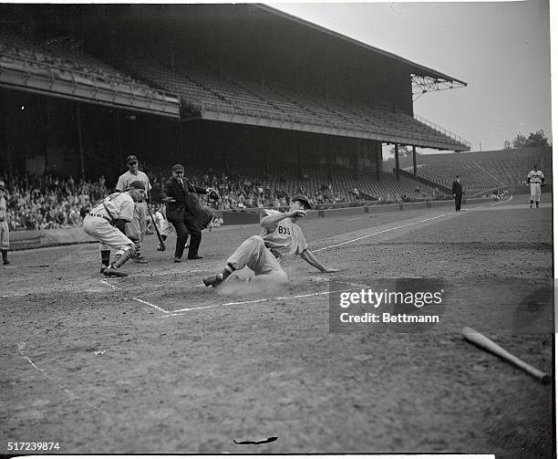 Ted Williams, her of the Boston Red Sox, is shown hitting the home plate with the run belted out by his own trusty Cudgel in the game against the...