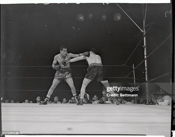 Tami Mauriello , Bronx heavyweight takes a glancing left from Joe Louis and retaliates with a right to the midriff. Action took place in the first...