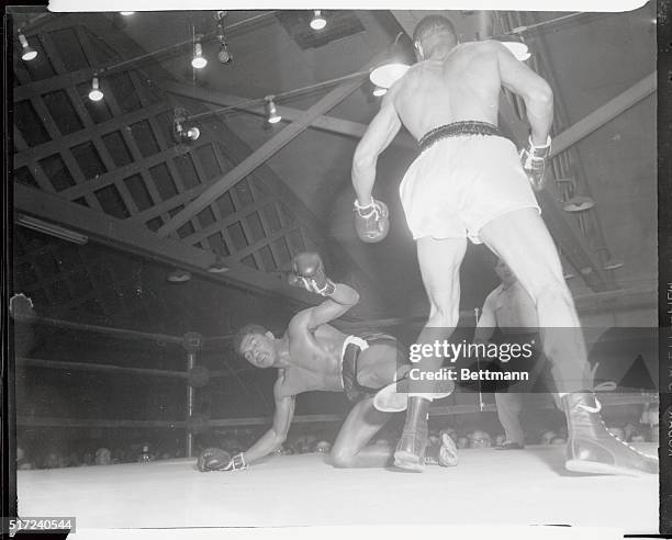Willie Troy, , of Washington, D.C., the middle;weight, is knocked down by New York's Tony Anthony in the second round of their scheduled ten round...