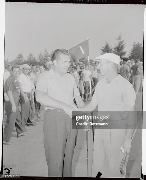 Julius Boros, of Southern Pines, North Carolina, is congratulated here by George Fazio of Pine Valley, New Jersey, after beating him on the first...