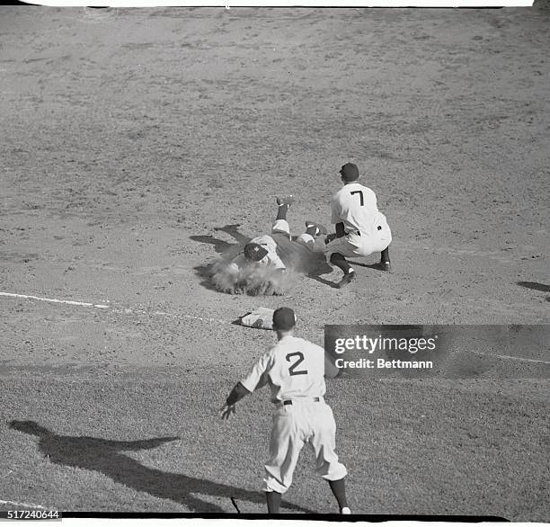 Yogi Berra, Yankees right fielder, plows safely into 3rd base on Robinson's single in 5th inning.