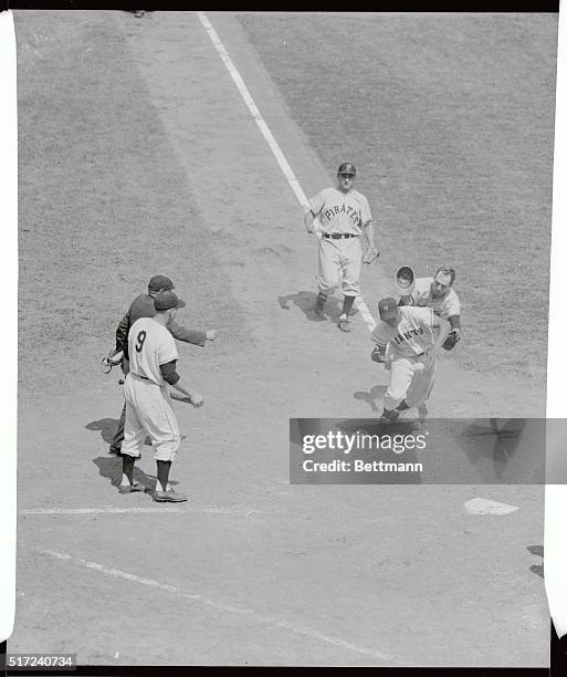 Reversing the usual occurrence, Willie Mays, with headpiece firmly in place, jars the cap off his head, and the ball from the luckless pitcher's...