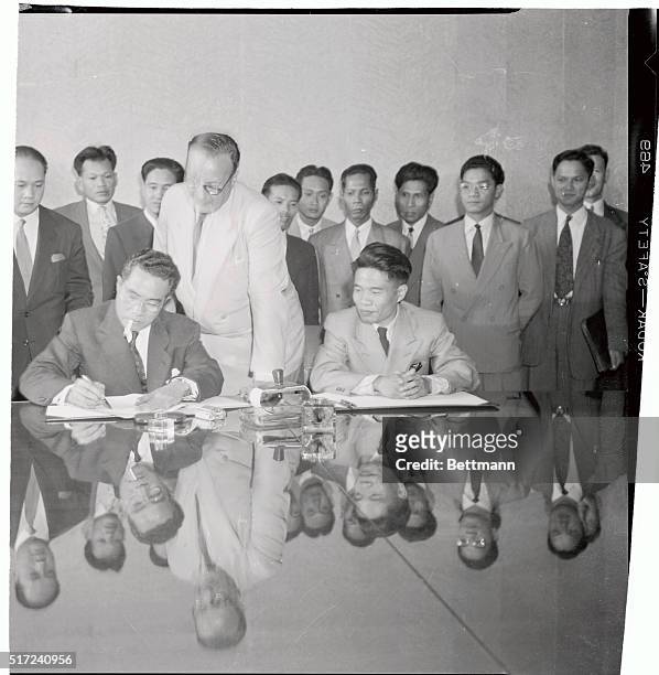 Cambodian defence minister General Nhiek Tioulono signs the cease fire treaty at Geneva, as Jean Paul Boncour, Secertary of the Asiatic Conference,...