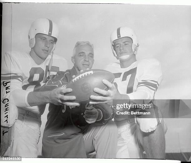 State College co-captains Jim Garrity and Don Balthaser check the pigskin with Coach Rip Engle, as Penn State opened football camp.