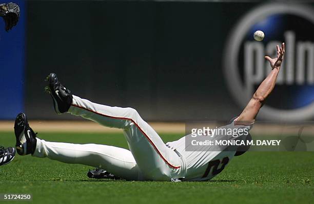 San Francisco Giants' right fielder John Vander Wal falls down but tries to bare hand the ball on a hit by Philadelphia Phillies' Robert Person who...