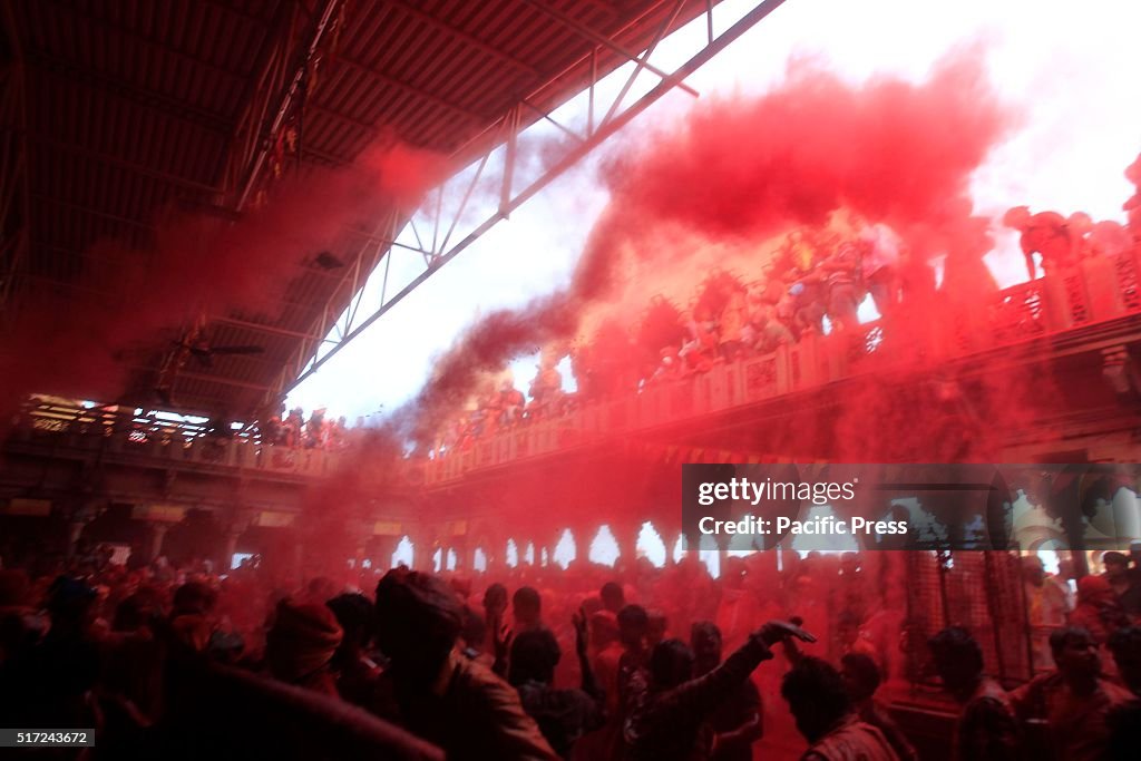 Indian hindu devotees throw colored powder and sing...