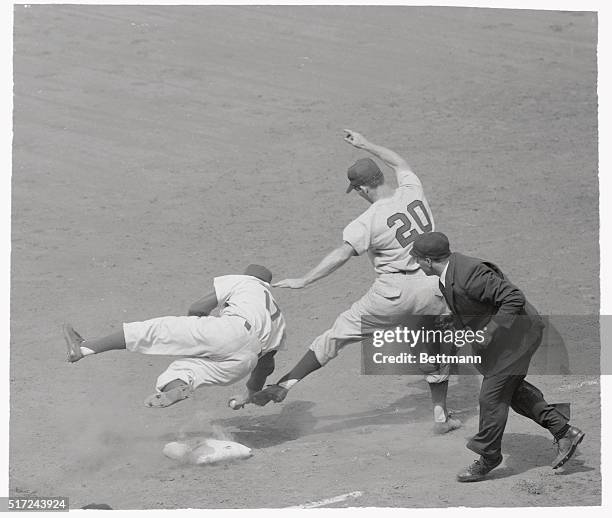Frozen in a dancelike play at first base are Brooklyn Pitcher Carl Erskine , who is momentarily airborne, Redlegs' Lloyd Merriman, just getting...
