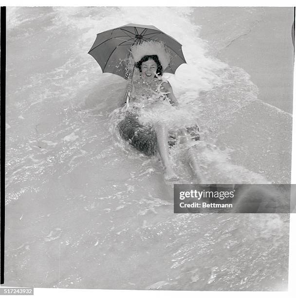 Nicki Norris feels there's no place like foam, but she'd just as soon be protected from the Florida sun, so she shields herself with an umbrella...