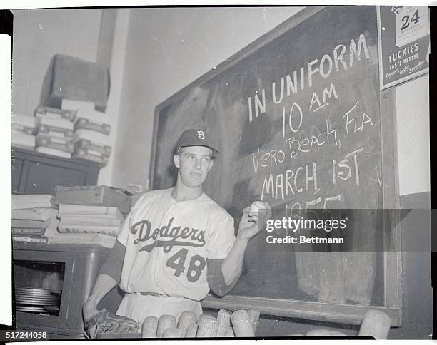 One of the most spectacular lads to help wind up the 1954 series, southpaw Karl Spooner points to a big sign on the dressing room blackboard, after...