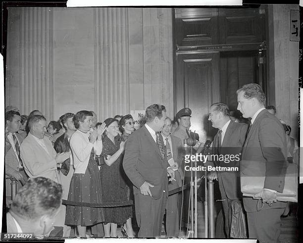 Spectators applaud Sen. Joseph McCarthy as he and his counsel Edward Williams emerge from Senate hearing room where a special Senate subcommittee is...