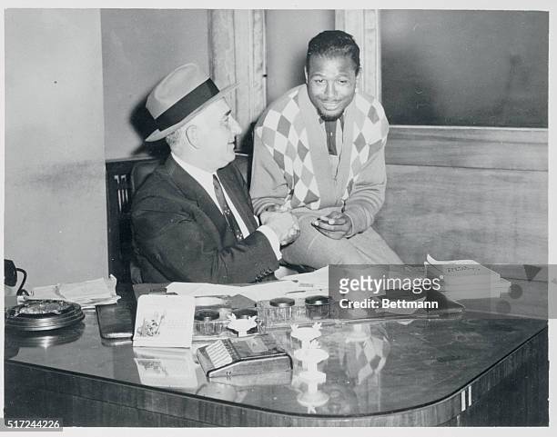 Sugar Ray Robinson signing with Nick Londes for his first comeback fight. The fight will be held at the Detroit Olympia Stadium, the early part of...