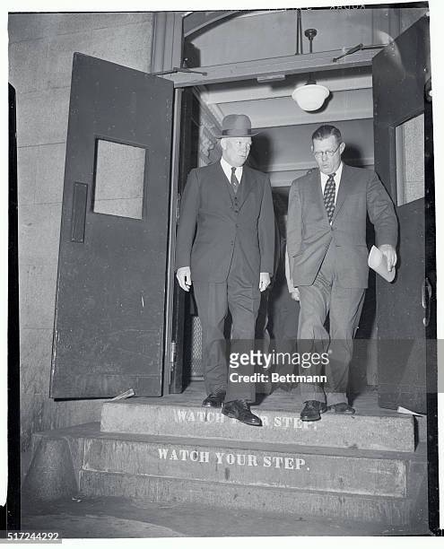 President Eisenhower and White House Press Secretary James Hagerty step carefully as they leave the Executive Office Building on their way back to...