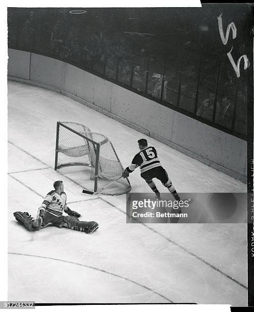 Lorne Worsley, goalie for the New York Rangers, finds himself in an embarrassing position as Milt Schmidt, Boston Bruins' Veteran, scores with only...