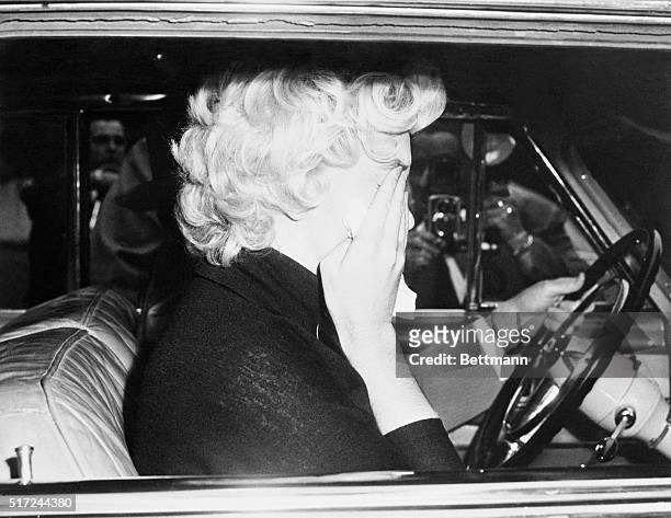 In this view through the window of Attorney Jerry Giesler's Cadillac, Film star Marilyn Monroe can be seen breaking down into tears after facing a...