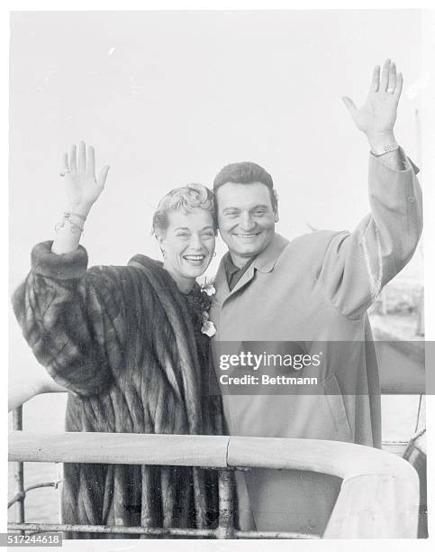 Crooner Frankie Laine and his wife wave goodbye from the deck of the French liner Ile De France as they leave Southampton. During a series of singing...