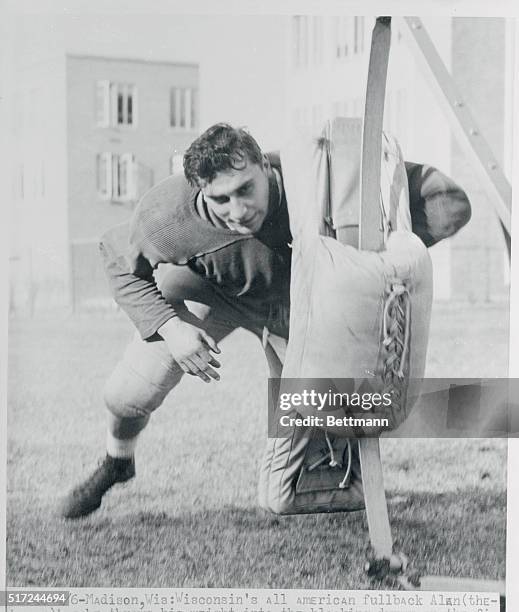 Wisconsin's All American fullback Alan Ameche, throws his weight into the blocking dummy on the first day of Spring practice at Camp Randall Stadium,...